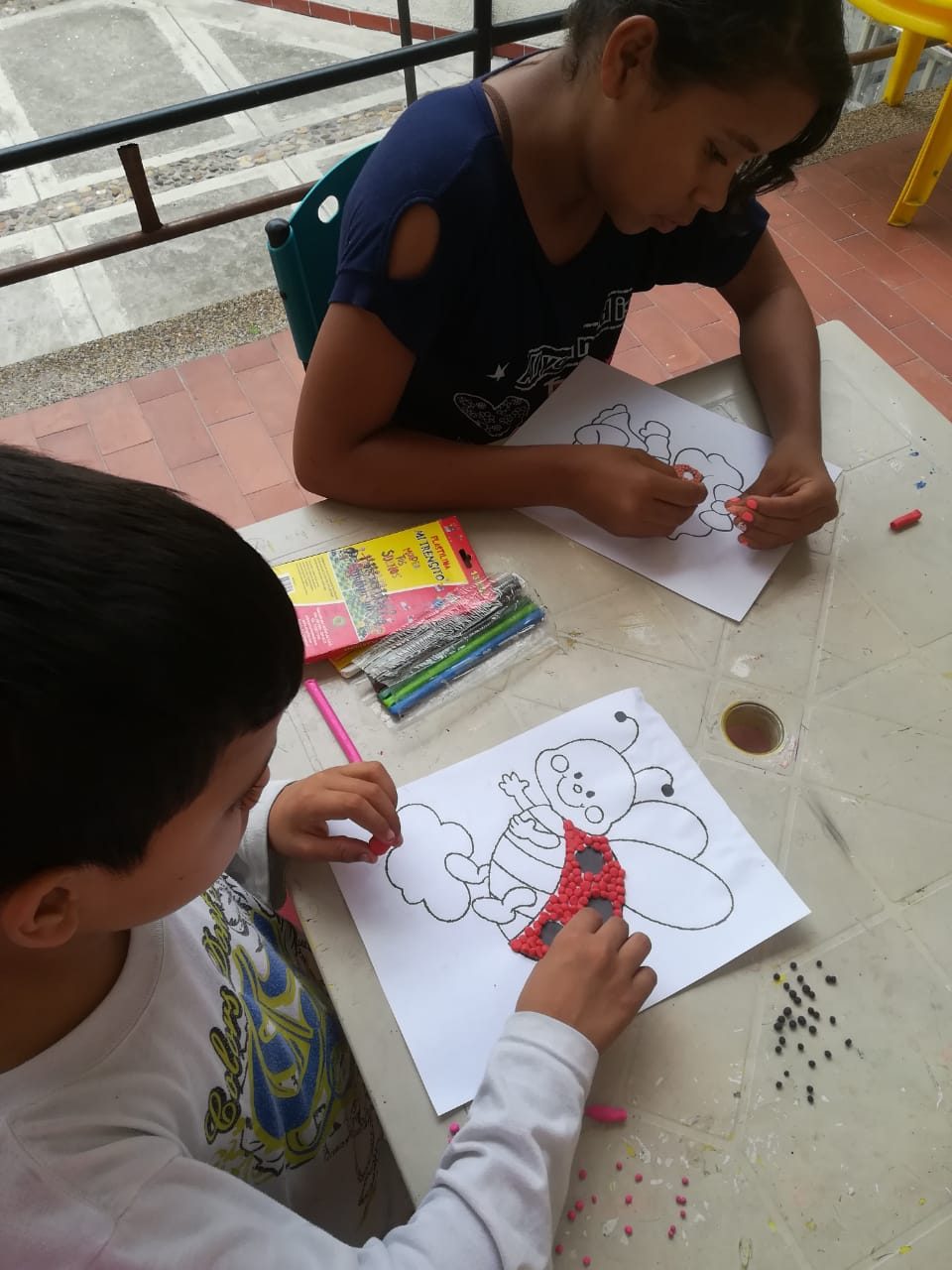 Niños haciendo manualidades en el hogar de paso