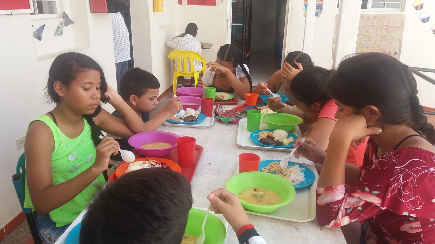 Niños compartiendo el almuerzo en el comedor comunitario